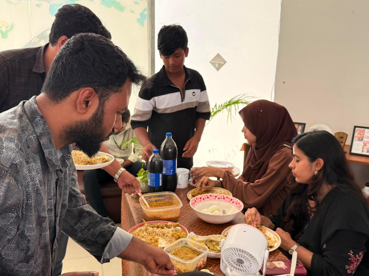 JBD IT-র কর্মীরা টেবিলে হরেক রকমের খাবার নিয়ে ওয়ান ডিশ পার্টির আড্ডায় মেতে আছেন